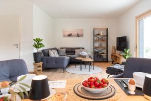 a living room with a couch and a table at ChiemseeFeeling in Übersee
