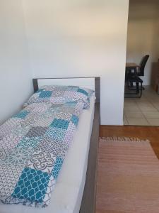 a bed with a quilt on it in a room at DaEl in Leoben