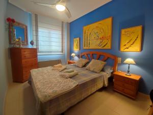a bedroom with a bed with a blue wall at Arenales del Sol Vista Bahía in Arenales del Sol +17 photos