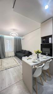 Una cocina y una sala de estar con mesa y sillas. en Квартира мечты в Центре города- ЖК Auezov City, en Almaty