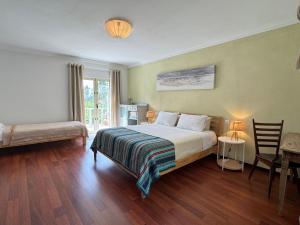 a hotel room with a bed and a table and a window at Wellbeing guesthouse Casa é Connosco in Alvaiázere