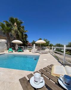 ノート・マリーナにあるAgriturismoeloropizzutaのテーブルとカップと椅子のあるプール