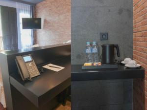 a desk with a phone and water bottles on it at JL World Hotel Dili in Dili