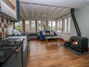 a kitchen with a stove and a living room at Grove House in Grange Over Sands