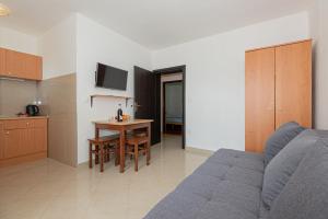 a living room with a blue couch and a table at Andrijas Apartments in Tribunj