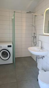 un bagno con lavatrice e lavandino di Haus FriesenHuus - Urlaub direkt an der Küste a Sehestedt Altre 16 foto