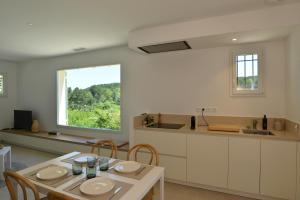 una cucina e una sala da pranzo con tavolo e finestra di Villa Le Gourdon - Piscine & Tranquillité a Barjac
