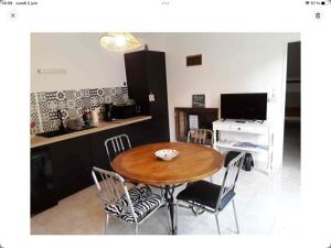 una cucina e una sala da pranzo con tavolo e sedie in legno di Gîte La Maison d Hélène a Millac