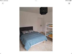 una camera da letto con un letto con una coperta blu di Gîte La Maison d Hélène a Millac