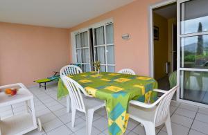 a dining room with a table and chairs on a balcony at Cap Esterel Garden Flat in Agay - Saint Raphael