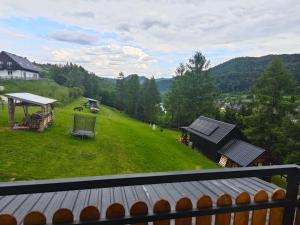 a view from the balcony of a house with a green field at Domek na Górce 3 in Krościenko +5 photos