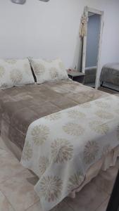 ein großes Bett mit einer Decke darauf in einem Zimmer in der Unterkunft Alojamiento LUNNA in Río Grande