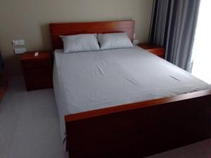 a bedroom with a large bed with a wooden headboard at Experience comfort convenience in Moratuwa