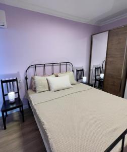 a bedroom with a large bed with white sheets and two chairs at Gonio Horizon Apartment in Gonio +11 photos