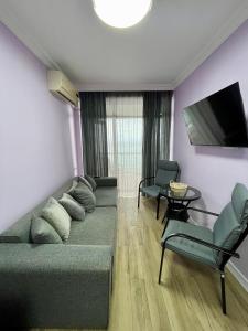 a living room with a couch and a tv and chairs at Gonio Horizon Apartment in Gonio +11 photos