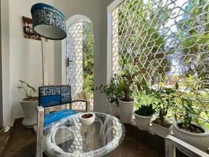 a room with a chair and a window with potted plants at Cosy One Bedroom Apartment-Diani in Diani Beach