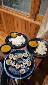 three plates of food on a table with rice at Kintsugi by Oztel in Kasol