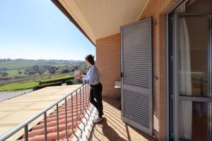 a woman standing on the balcony of a building at Hotel Palazzo Bello in Recanati +52 photos