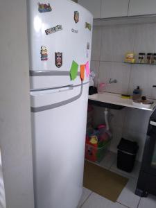 a white refrigerator with magnets on it in a kitchen at Apartamento Morada do Vale 1 andar - Área de Lazer - Estacionamento - Internet e Netflix GRATUITO in Garanhuns +3 photos