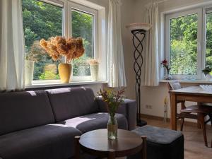 a living room with a couch and two windows at 't Veldhuisje in Kootwijkerbroek