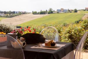 a table with a plate of food and a field of flowers at Hotel Palazzo Bello in Recanati