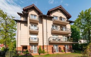 Un gran edificio con balcones a los lados. en RizaVilla, en Krynica Morska