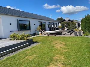 a house with a hammock in the yard at Villa med jacuzzi in Hørning
