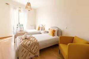 a bedroom with a bed and a couch and a chair at Sunset Retreat in Nazaré