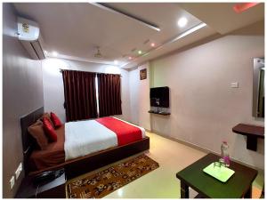 格德拉HOTEL SHREE SUVIDHA DHAM Near Bypass Road的一间卧室配有一张床、一台电视和一张桌子