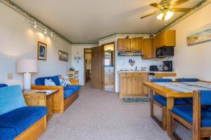 a living room with a blue couch and a kitchen at Assateague Inn 109-S in Deep Hole