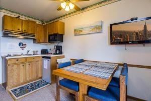 a kitchen with a wooden table and a table and chairs at Assateague Inn 109-S in Deep Hole