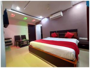 格德拉HOTEL SHREE SUVIDHA DHAM Near Bypass Road的卧室里有一张大床，配有红色枕头