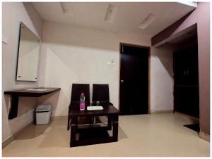 格德拉HOTEL SHREE SUVIDHA DHAM Near Bypass Road的一间有桌子、镜子和黑色门的房间