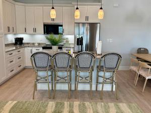 een keuken met een tafel met stoelen en een koelkast bij New Build - Pool - Walk to Beach in Fort Myers Beach
