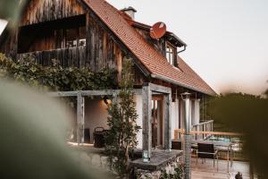 a wooden house with a table and chairs in front of it at Ferienhaus Am Grassnitzberg 18 in Straß in Steiermark