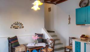 a dining room with a table and chairs and stairs at Pano Gitonia in Aegiali