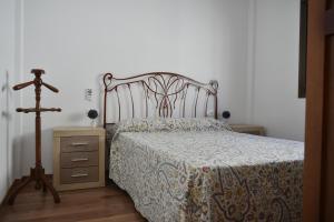 a bedroom with a bed and a wooden dresser at Acogedor apartamento con terraza y vistas al mar in Enix