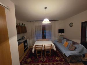 una sala de estar con una mesa y un sofá en Apartman Eco, en Jezerce