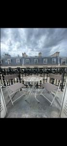 a table and chairs on a balcony with a building at Appartement avec Terrasse 14 ème in Paris