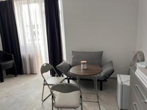 a small table and chairs in a room with a table and chairs at LA PLAYA - Camere pe plaja cu sezlong gratuit in Eforie Nord