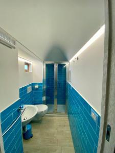 a blue and white bathroom with a toilet and a sink at Holiday House ROSANNA in Conca dei Marini