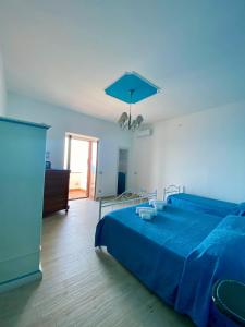 a bedroom with a blue bed with a blue blanket at Holiday House ROSANNA in Conca dei Marini