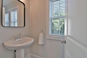 a white bathroom with a sink and a mirror at Island Home Retreat in Knoxville +24 photos