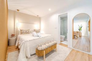 a white bedroom with a large bed and a mirror at Seventy Four House in Braga