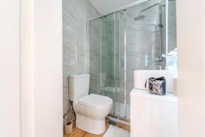 a bathroom with a toilet and a glass shower at Seventy Four House in Braga