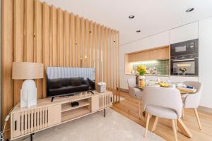 a living room with a television and a dining room at Seventy Four House in Braga