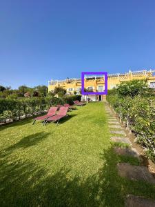 een rij rode banken in een grasveld bij Albufeira Luxury Villa in Albufeira