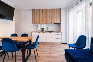 a kitchen and dining room with a table and chairs at Apartamenty Pod Wyciągiem in Wisła