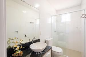 a bathroom with a toilet and a sink and a shower at Apto 450m da praia c/ churrasq. e 3 suítes TAH0602 in Meia Praia +23 photos