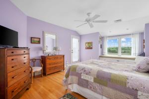 a bedroom with a bed and a dresser and a tv at 69 Salt Marsh Road East Sandwich - Cape Cod in East Sandwich